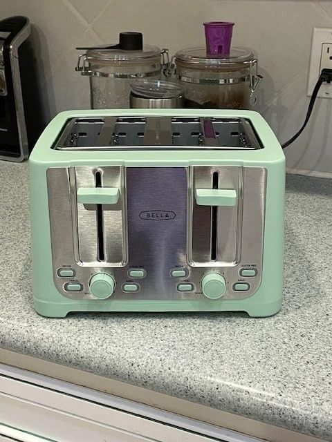 A mint green Bella four-slice toaster featuring dual control settings, displayed on a kitchen counter
