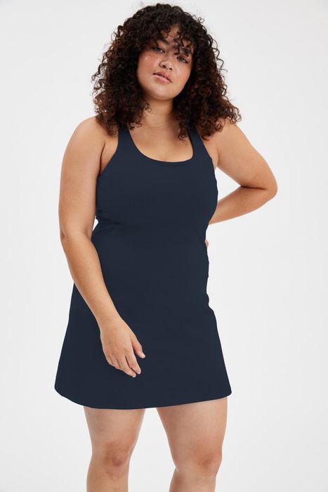 A model in a black tank mini dress.