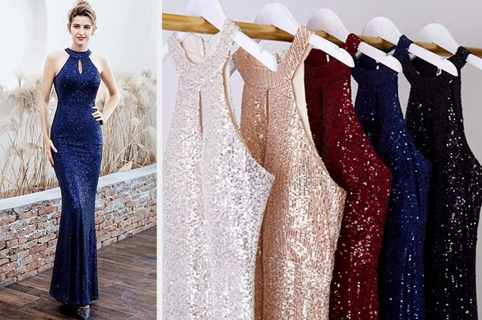A model stuns in a navy blue halter sequin mermaid dress featuring a keyhole cutout at the top, paired with glittery pointed heels, standing amidst plants. The products, in shades of white, nude, red, navy, and black, hang elegantly on a wooden rod.
