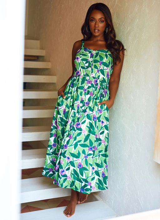 Model in a sleeveless, sweetheart neckline button-front dress with a green leaf and purple flower print