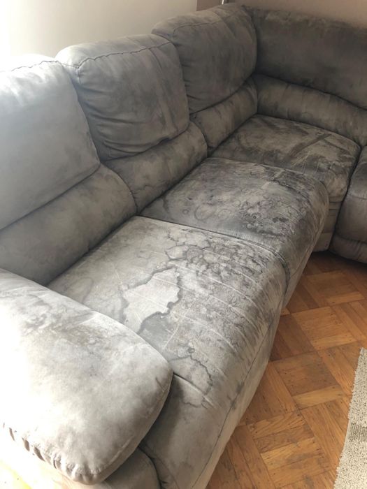 reviewer before image of a gray couch displaying noticeable dark stains