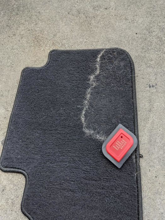 A reviewer’s photo of their car’s carpet, showing a noticeable pile of fur that has been removed by the detailer