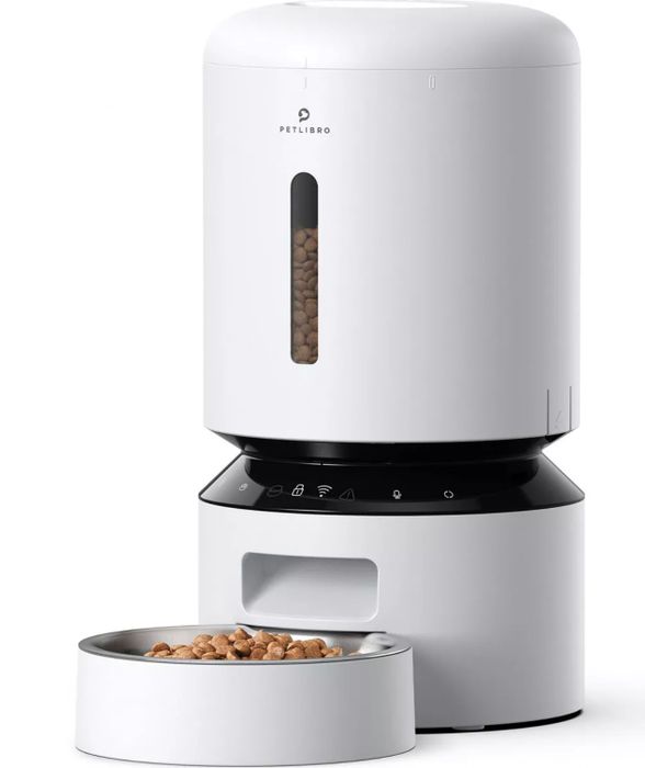 An automatic pet feeder with food in its bowl and a compartment full of kibble.