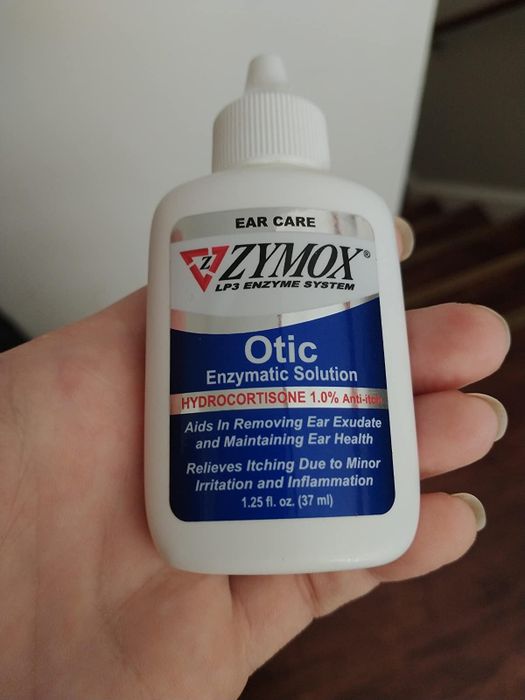 image of a hand holding the bottle of ear treatment