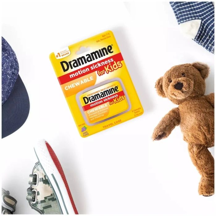 Dramamine Kids packaging, displayed alongside a child’s teddy bear, clothes, and sneaker