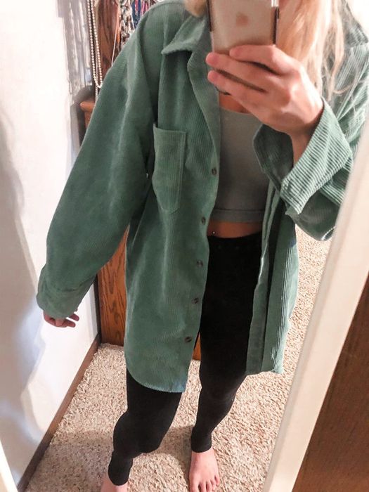 reviewer styling the green button-up shirt open with a tank top layered underneath