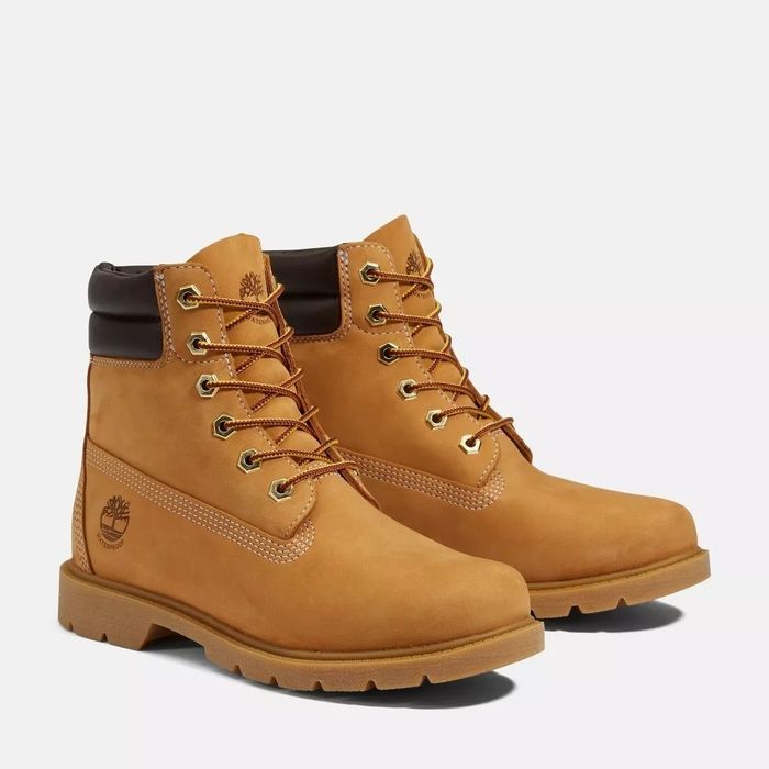 A pair of Timberland waterproof boots featuring golden eyelets and laces, with the Timberland logo prominently embossed on the side.