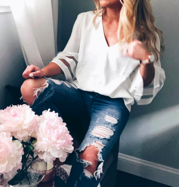 A customer review photo showcasing the bell-sleeve blouse in white, worn by them