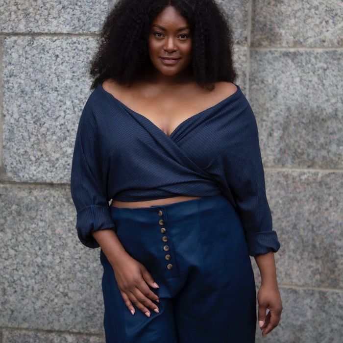 A model showcasing a navy blue wrap top paired with blue pants