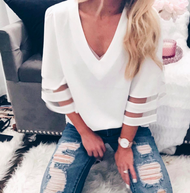 A customer review photo featuring the bell-sleeve blouse in white, styled by them