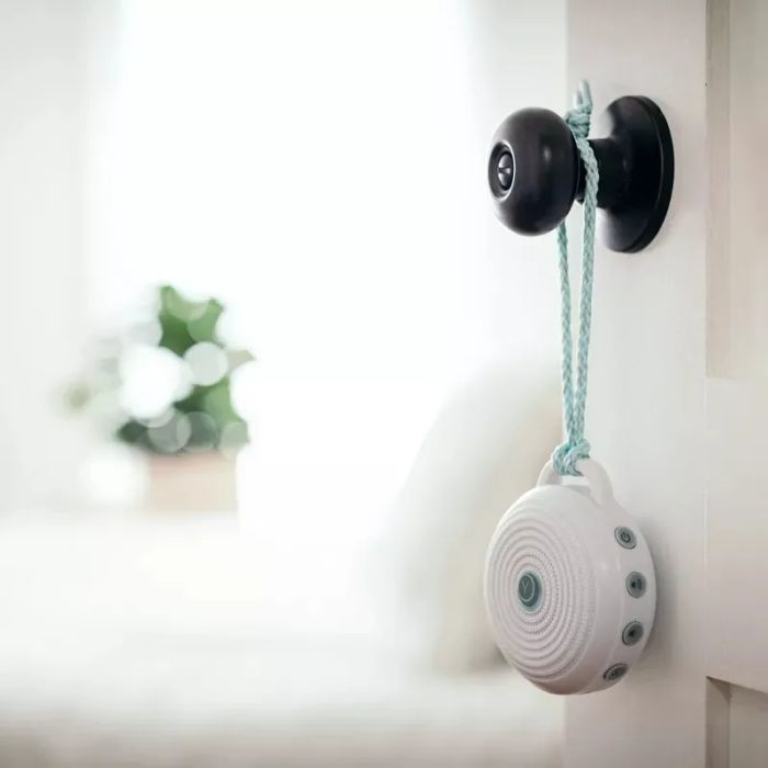 A sleek, modern portable doorbell attached to a door