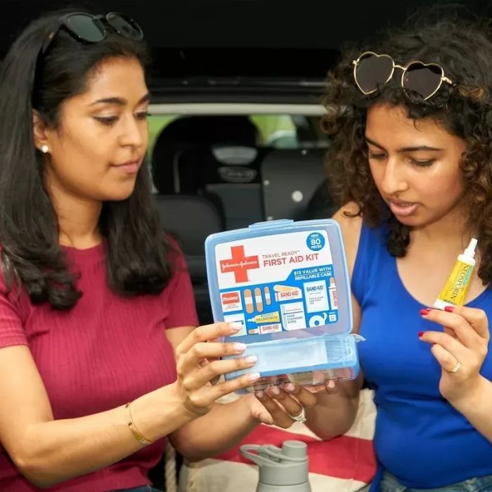 Two women inspecting the contents of a first aid kit, highlighting practical preparation for safety needs