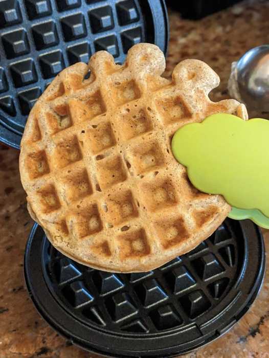 a reviewer capturing the moment of removing a freshly made waffle from the mini iron