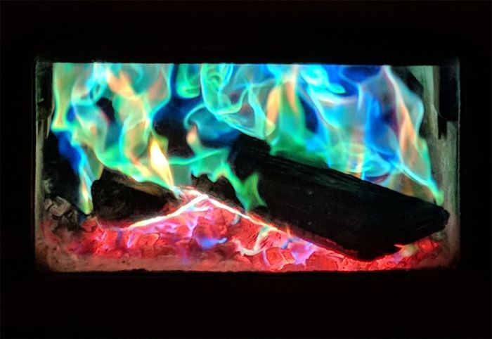 an indoor fireplace glowing with multicolored flames