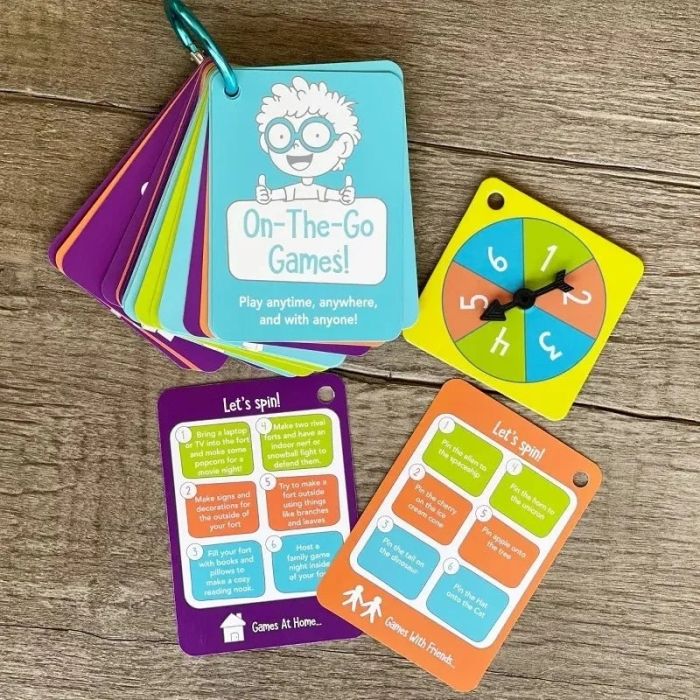A collection of On-The-Go Games cards paired with a clock spinner, ideal for interactive and travel-friendly fun