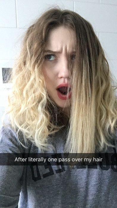 A Mytour editor with thick, curly hair, shocked after straightening one section with the brush, her expression showing amazement.