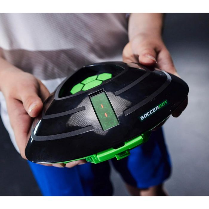 A person holding a robotic soccer training device equipped with a digital display, ideal for improving soccer skills and available for purchase