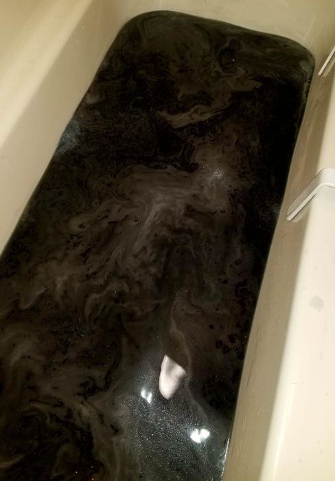A tub filled with shimmering black water.