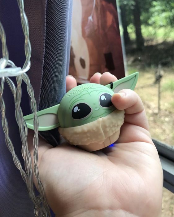 A reviewer holding a palm-sized Baby Yoda