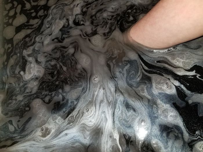 A close-up view of the iridescent black water.