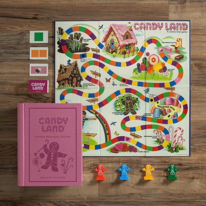 Candy Land board game set featuring a vibrant game board, character pieces, and cards. The Vintage Bookshelf Edition comes with a pink hardcover book-style box.