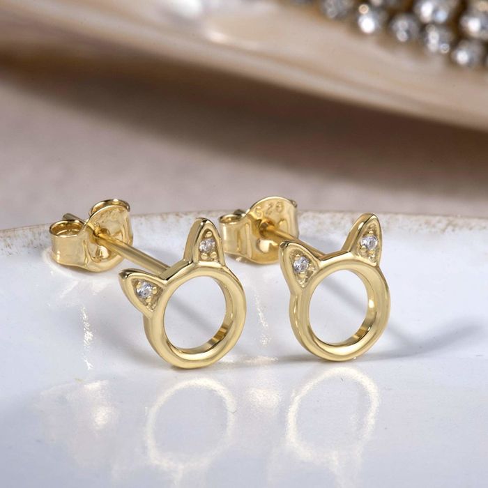 Gold cat face-shaped stud earrings adorned with tiny rhinestones on the ears.