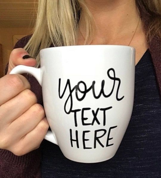 A model holding a large white mug with the placeholder text "Your text here" in black lettering.