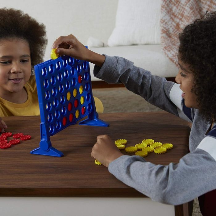 A photo of two children playing a game of Connect 4.