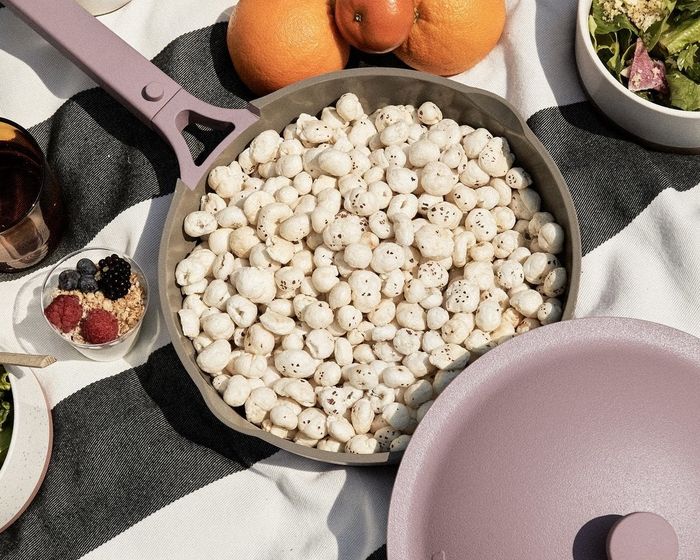 Popped lotus seeds being served in the lavender pan, with the basket removed and the lid off.