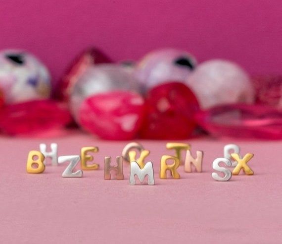 Gold, rose gold, and silver letter stud earrings.