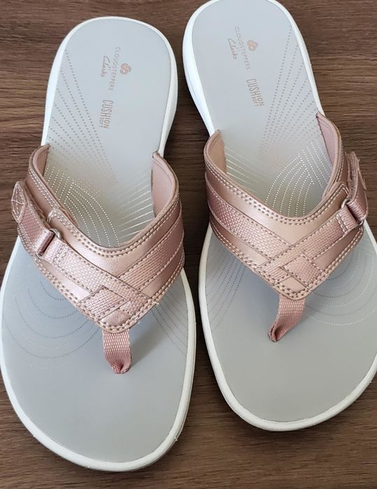 a photo of flip-flops with rose gold straps, shared by a reviewer