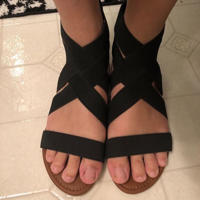 a reviewer wearing the black version of the sandals