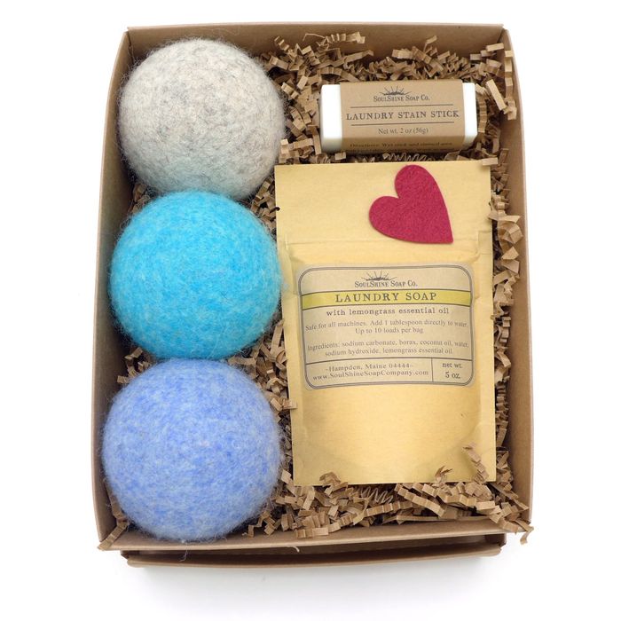 The gift box containing gray, blue, and bright blue dryer balls, the soap, and the stain stick.