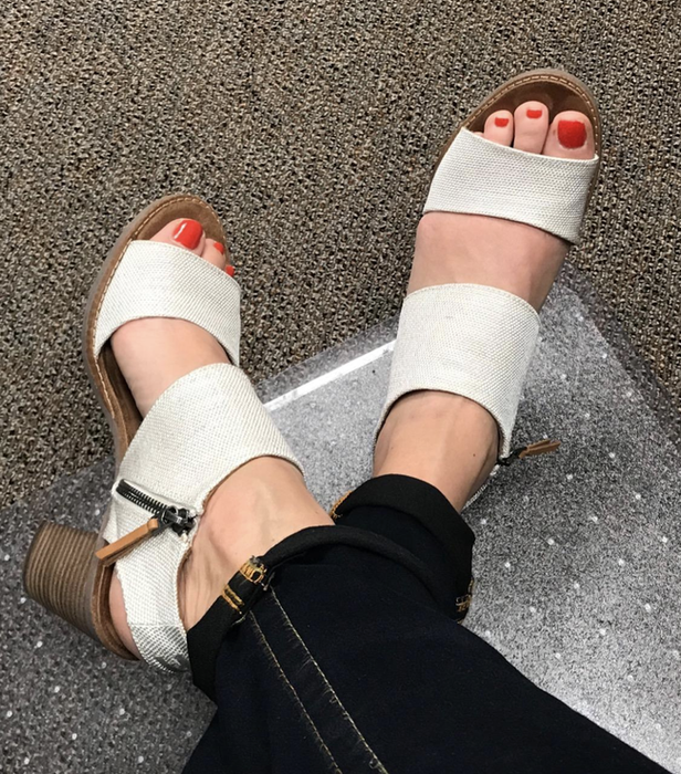 reviewer wearing heels featuring white canvas straps and a side zipper
