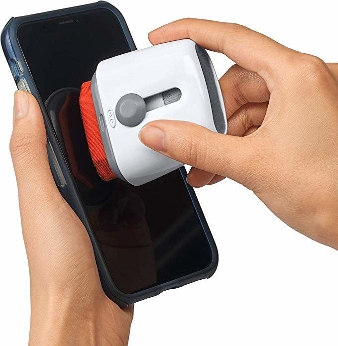 A hand using the microfiber side to clean a phone screen.