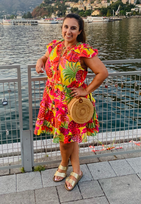 writer wearing the gold Birkenstocks with a colorful dress while on vacation