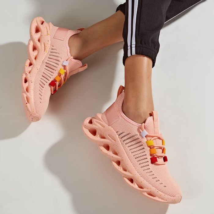 model wearing pink chunky platform sneakers with colorful lace details