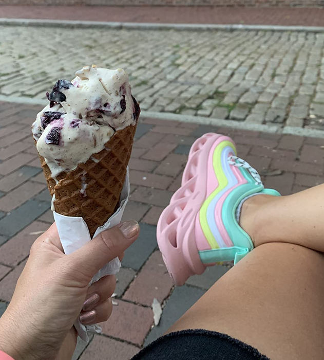 reviewer wearing the same pink, yellow, and blue sneakers while holding an ice cream cone