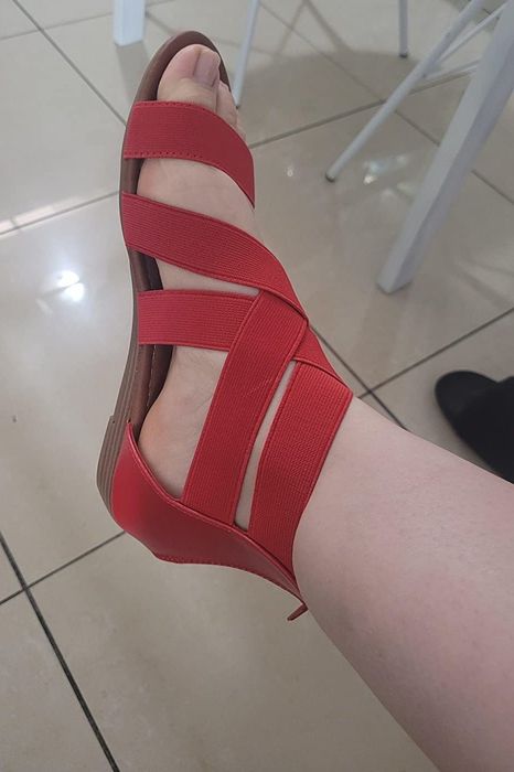 a side view of a reviewer’s feet in the red sandals