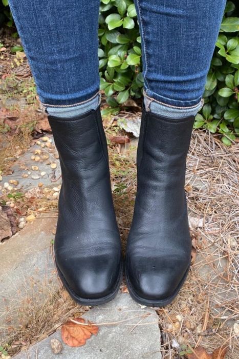 a photo of a reviewer outdoors, wearing jeans paired with the black ankle boots