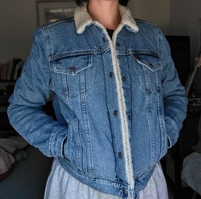 A reviewer modeling the medium-wash snap-button jacket with a cream fleece lining and collar.