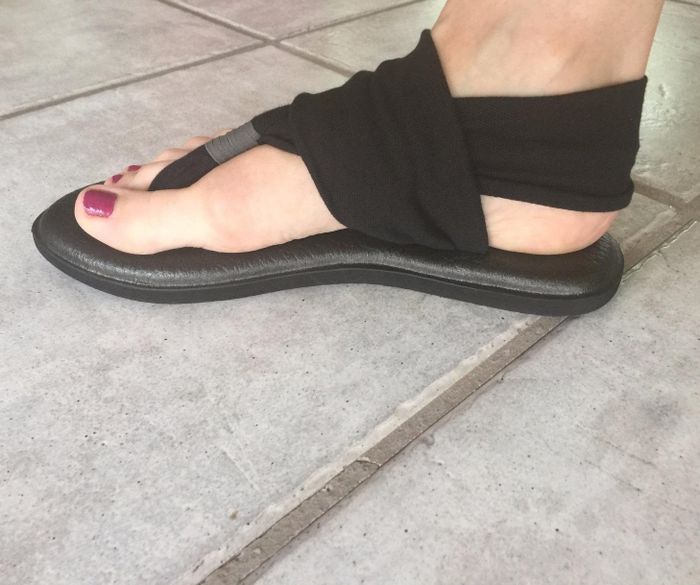 photo of black flat sandals with an ankle sling strap, side view, taken by a reviewer