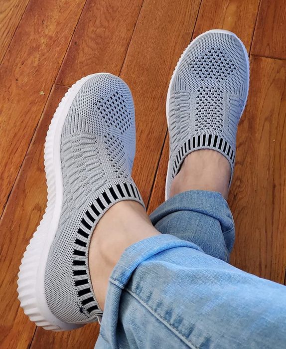 reviewer wearing the grey knit sneakers