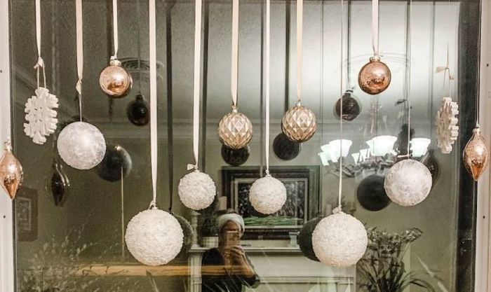 Treo các quả châu để trang trí cửa kính Noel độc đáo