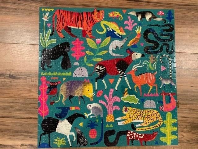 a puzzle displayed on a reviewer’s table featuring animals such as a leopard, tapir, gorilla, tiger, lemur, and anteater