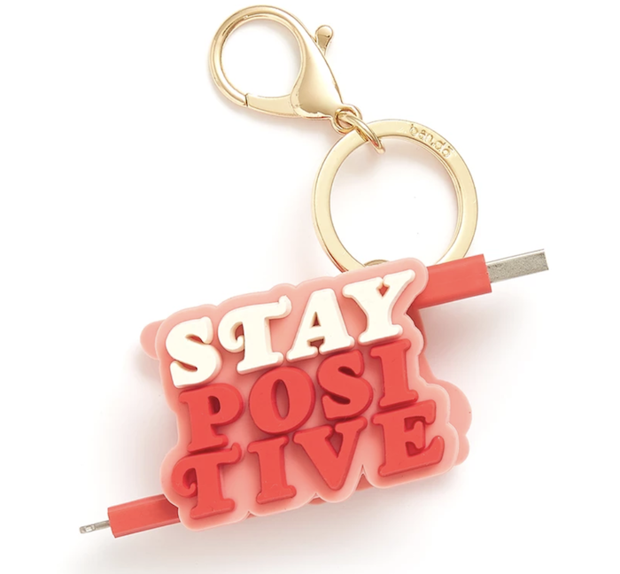 A pink and white charger with the cheerful message 'Stay Positive' on it.