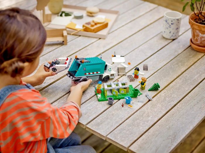A child interacts with a Lego recycling truck.