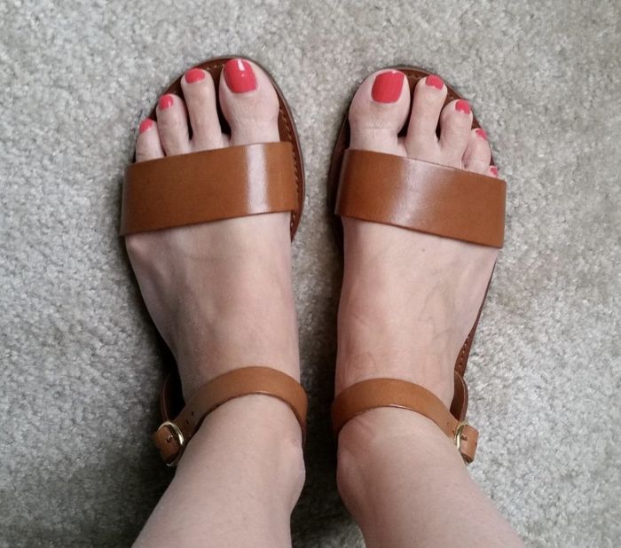 Tan sandals featuring thick straps, offering a stylish and supportive fit.