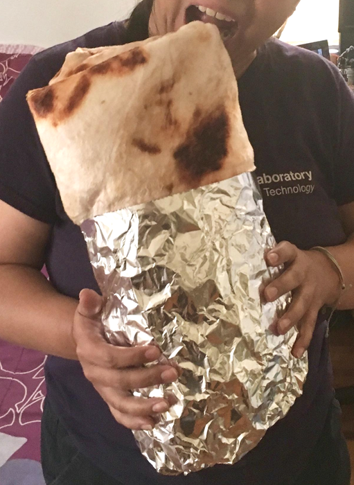 The burrito blanket is wrapped like an actual burrito, complete with a rectangular shape and partially covered in aluminum foil. A reviewer shared this image showing how they wrapped the blanket as a gift.