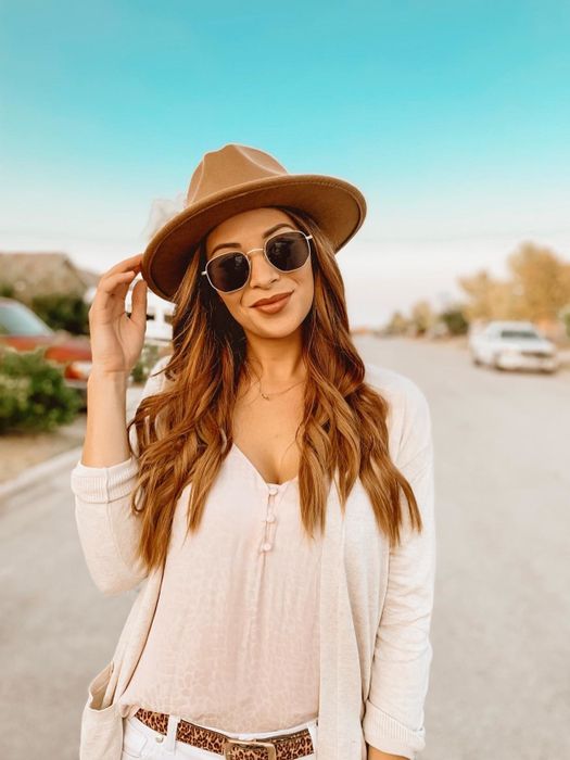 A reviewer modeling the gold-framed sunglasses